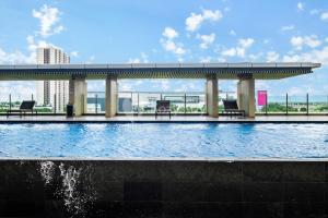 a swimming pool with a bridge over a body of water at Carrara by Kozystay - BSD in Tangerang