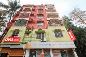 a tall yellow and red building with a store at Super Hotel O Adri Hotels in Kolkata