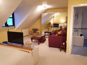 a living room with a couch and a television at The Old Cornstore a beautiful Suite overlooking the sea in Drummore