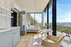 a kitchen with a table and a bedroom with a bed at Tiny Marienholm in Haapsalu