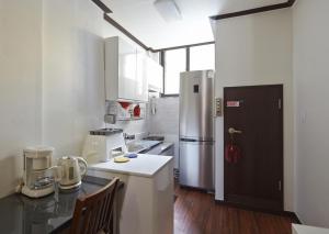 a kitchen with a refrigerator and a counter top at Jiwoljang Guesthouse in Seoul