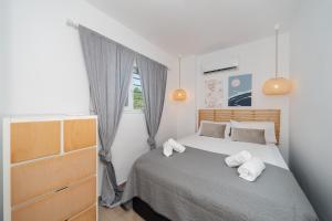 a bedroom with a bed with two towels on it at Sandlight Apartment by A&D Properties in Porto Rafti +16 photos