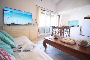 a living room with a couch and a table and a tv at Porto Rotondo home with Pool access & Sea Views in Porto Rotondo