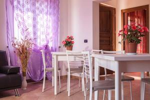 a living room with a table and chairs and flowers at B&B Monte San Pietro in Urbania