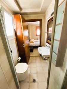 une salle de bain avec toilettes et lavabo et un lit dans l'établissement Koneva House, à Koskinou