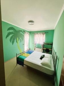 - une chambre avec un lit orné d'un palmier peint sur le mur dans l'établissement Koneva House, à Koskinou 23 autres photos