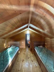 une chambre avec deux lits dans une cabane en bois dans l'établissement Forest Cottage, à Sadgeri