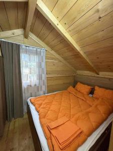 un lit dans une chambre avec un plafond en bois dans l'établissement Forest Cottage, à Sadgeri