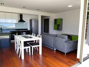 a living room with a table and a couch at Charmant appartement central avec jardin privé in Papeete +14 photos