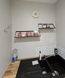a kitchen with a sink and a clock on the wall at The View Randalstown in Randalstown