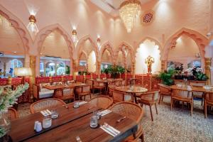 a restaurant with wooden tables and chairs in a room at Impiana Private Villas Seminyak in Seminyak