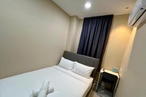 a bedroom with a white bed with a window at Infinity Hotel Iskandar Puteri in Iskandar Puteri