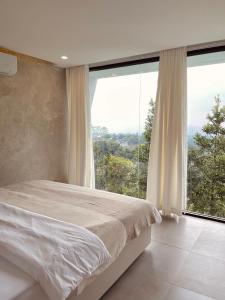 a bedroom with a bed and a large window at Villa Morris By The Villas 100 in Cilama +28 photos