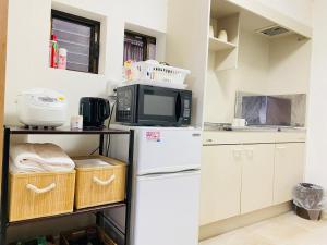 a kitchen with a white refrigerator and a microwave at Umeda Yodogawa Cozy Home B 步行5分钟到JR站 直达京都神户 Umeda 1站 新大阪2站 in Osaka
