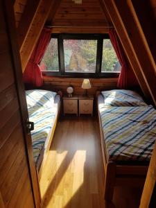 two beds in a small room with a window at Nurdachhaus mit Kaminofen und großem Grundstück in Faßberg