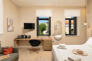 a bedroom with a bed and a desk with a mirror at The Alma City Hotel in Chania Town