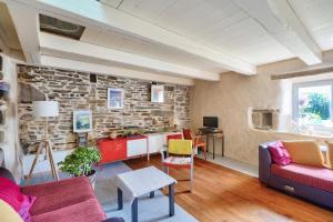 un salon avec un mur en pierre dans l'établissement 1km de la plage, maison de charme pour 6, à Plovan