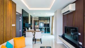 a living room with a white couch and a television at Apartment 2 bedrooms on Surin in Surin Beach