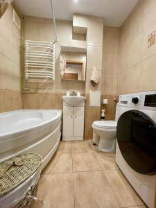 a bathroom with a tub and a toilet and a sink at komfortowy pokoj dla pary in Kołobrzeg
