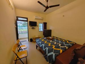 een slaapkamer met een bed en een plafondventilator bij Vinsons Cottages in Colva