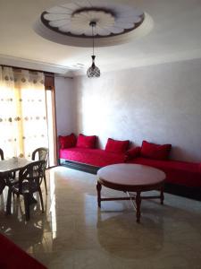 a living room with a red couch and a table at Location saisonnière in Settat