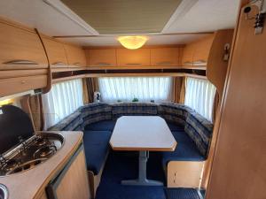 a small dining room in an rv with a table at Caravan Petiet in Buren