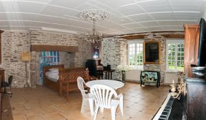un soggiorno con un tavolo e una camera da letto di Maison de maître de 1789 rénovée avec piscine a Roannes-Saint-Mary