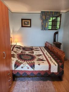 a bedroom with a bed with a quilt on it at Hiša Heidi in Zavrč