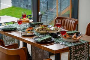 a table with plates of food and wine glasses at Greenwood Hotel Restaurant & Spa in Batumi