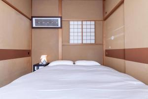 a bedroom with a large white bed and a window at Daini Kuwamura Building 4th in Tokyo