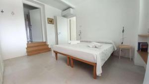 a white room with a bed and a table at Casa Mavi in Colombaro