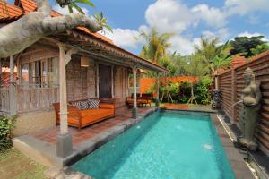 a villa with a swimming pool and a house at Suarti Boutique Village in Ubud