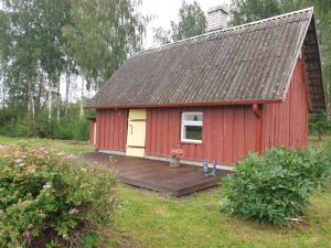 a red barn with a deck in a yard at Kure talu Glämping Setomaal in Polovina +10 photos