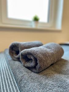 a pile of towels sitting on top of a bed at Moderne Monteurswohnungen in zentraler Lage in Bad Bramstedt in Bad Bramstedt