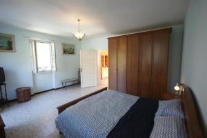 a bedroom with a bed and a wooden cabinet at Dell' Oca in Cissano +13 photos