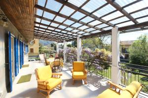 a screened porch with yellow chairs and a pergola at Dell' Oca in Cissano