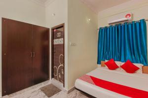 - une chambre avec 2 lits dotés de rideaux bleus et d'oreillers rouges dans l'établissement Goldhorn Hotels & Banquet Mehdipatnam Near St Ann's college, à Hyderabad