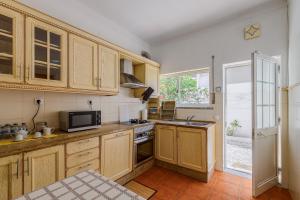 a kitchen with wooden cabinets and a microwave at Alojamento Local Coruche Erra in Coruche