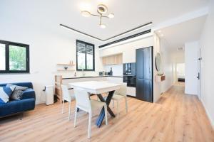 Una cocina y una sala de estar con una mesa y sillas blancas. en Elegance 3 BR in Gordon Beach by HolyGuest, en Tel Aviv