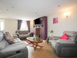 カーナーヴォンにある43 Hyfrydle Roadのソファ2つとテーブルのあるリビングルーム