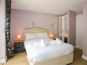 カーナーヴォンにある43 Hyfrydle Roadの大きな白いベッドと2つのランプのある寝室