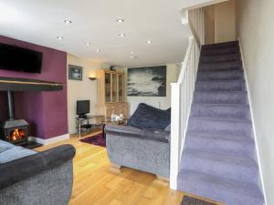 a living room with a staircase and a couch at 42 Hyfrydle Road in Caernarfon