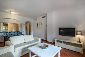 a living room with a couch and a tv at Hoyo I by Ĥ - Isla Canela Golf GHHI16B2P75 in Isla Canela