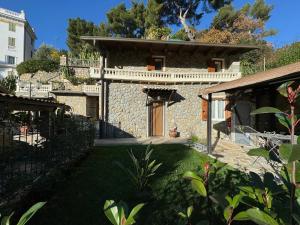 una casa in pietra con un cortile davanti di La Maison de Luisa a Bordighera