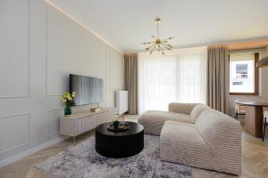 a living room with a couch and a table at Holzera Prestige Apartment in Warsaw