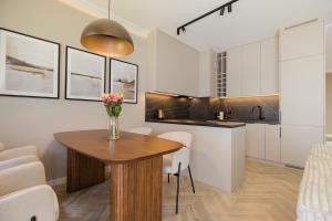 a kitchen and dining room with a table and chairs at Holzera Prestige Apartment in Warsaw