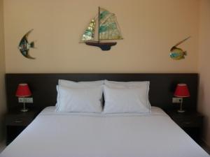 ein Schlafzimmer mit einem Bett mit zwei Lampen und einem Fenster in der Unterkunft Blue Harmony Apartments in Plaka
