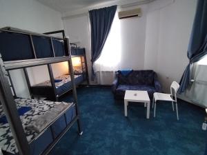 a room with bunk beds and a couch and a table at Hostel Koprivnica in Koprivnica