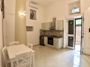 a kitchen with a table and a white table and chairs at Cozy Studio in Pisciotta