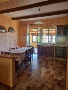 a dining room with a table and a kitchen at Costa di Mare in Monasterace